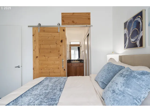 a bedroom with a bed and a refrigerator