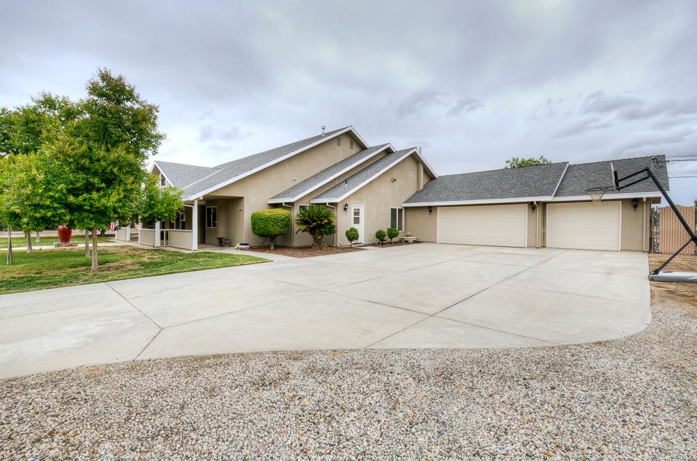 17465 Monreal Road Madera, CA 93636 - Photo 6 of 59 a front view of a house with a yard and garage