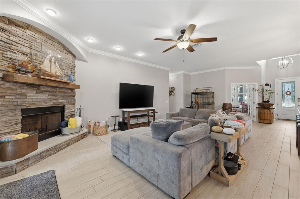 14582 Boland Avenue Spring Hill, FL 34610 - Photo 12 of 74 a living room with furniture a flat screen tv and a fireplace