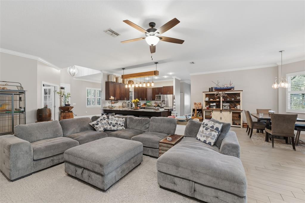 14582 Boland Avenue Spring Hill, FL 34610 - Photo 14 of 74 a living room with furniture kitchen view and a chandelier