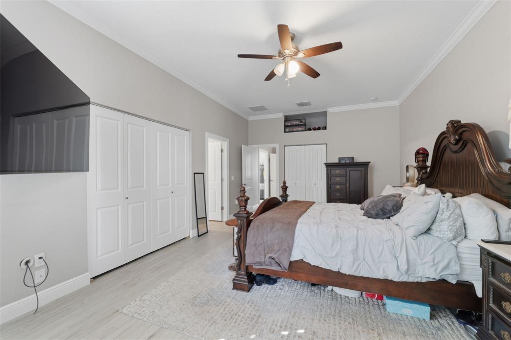 14582 Boland Avenue Spring Hill, FL 34610 - Photo 27 of 74 a bedroom with a bed and a chandelier