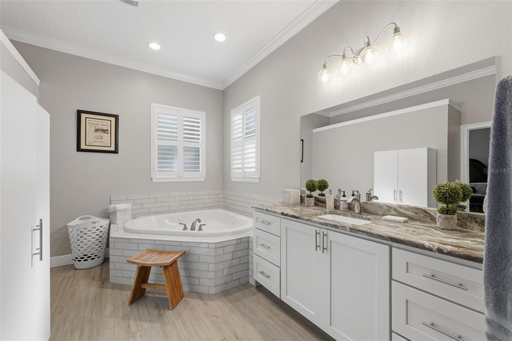 14582 Boland Avenue Spring Hill, FL 34610 - Photo 28 of 74 a bathroom with a double vanity sink a mirror and a bathtub