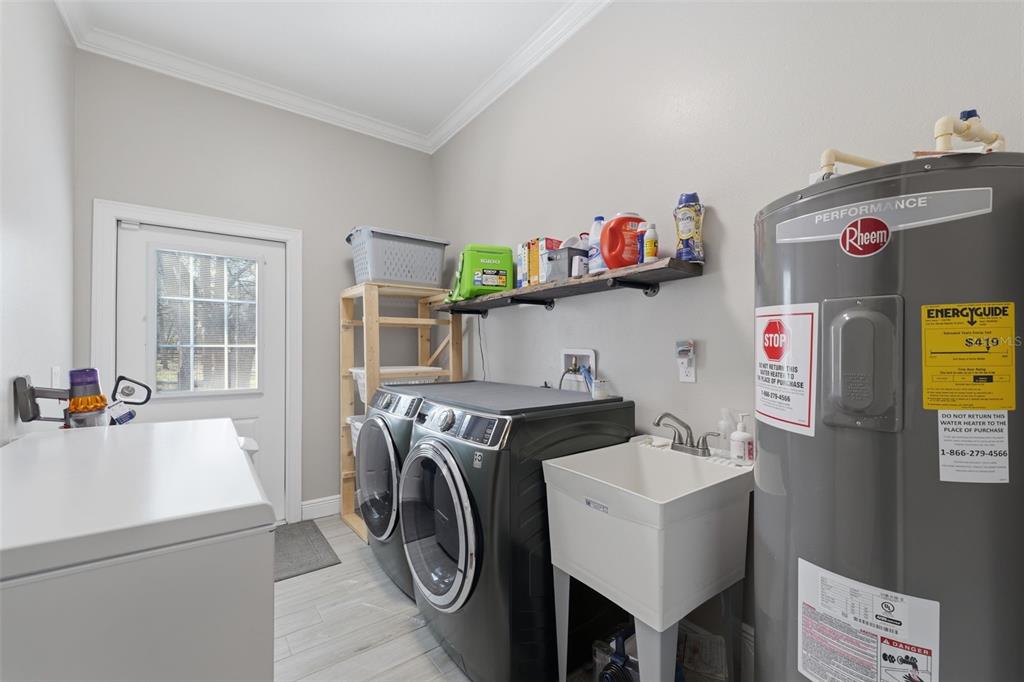 14582 Boland Avenue Spring Hill, FL 34610 - Photo 40 of 74 a utility room with dryer washer and a view of living area