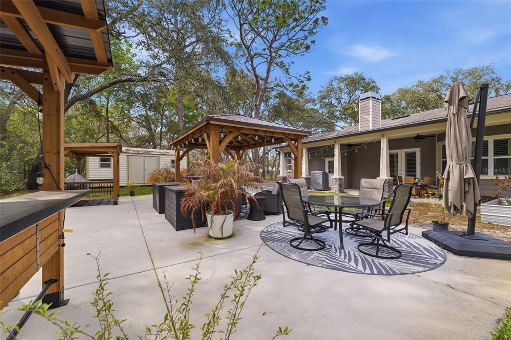 14582 Boland Avenue Spring Hill, FL 34610 - Photo 46 of 74 a view of a patio with table and chairs and potted plants