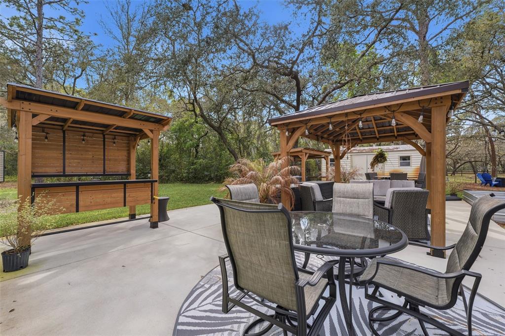 14582 Boland Avenue Spring Hill, FL 34610 - Photo 48 of 74 a view of a patio with a table chairs and a backyard
