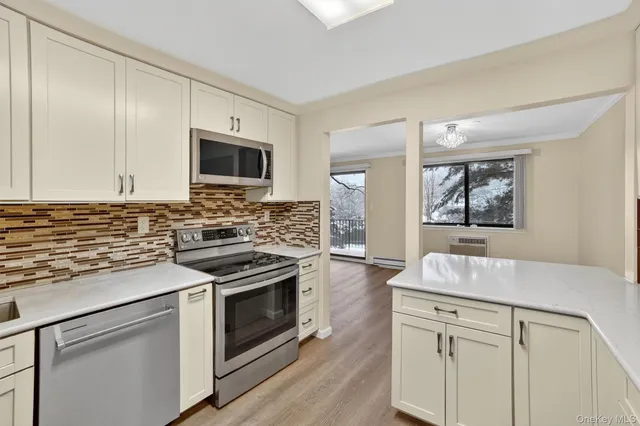 a kitchen with granite countertop white cabinets and wooden floor