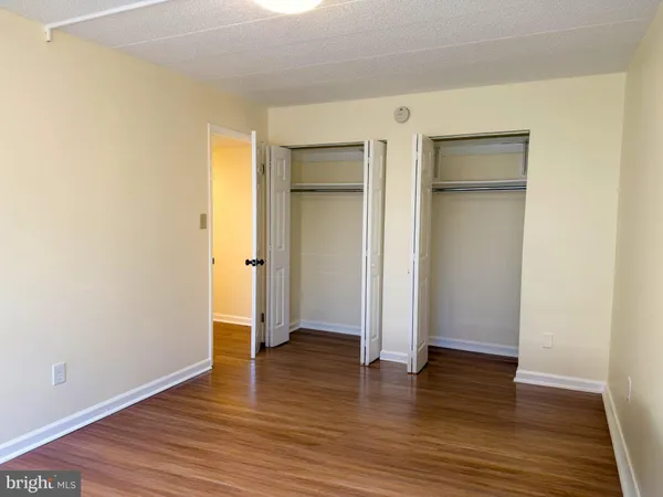 an empty room with wooden floor & closet