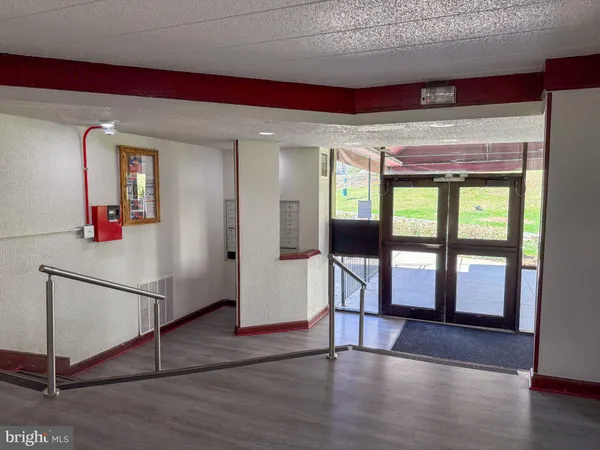 a view of a hallway with wooden floor and windows