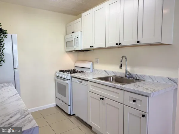 a kitchen with white cabinets and white appliances