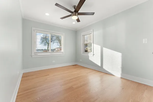 an empty room with windows and fan
