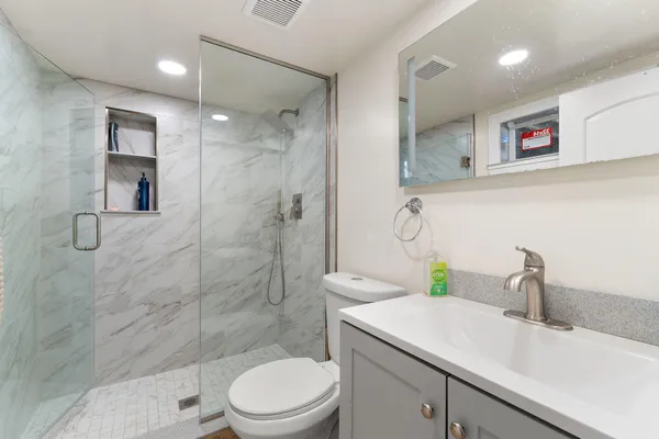 a bathroom with a sink a toilet and shower