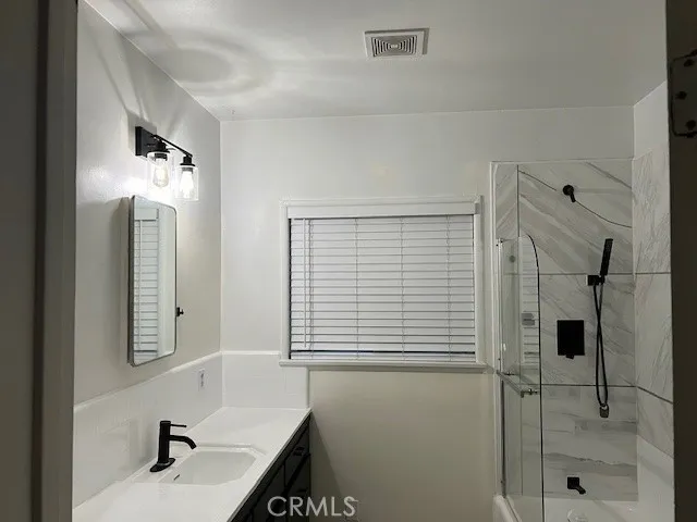 a bathroom with a sink a shower and a mirror