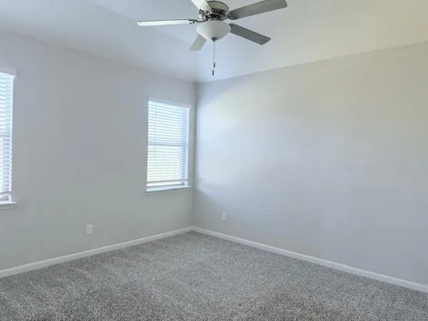 an empty room with a window and a fan