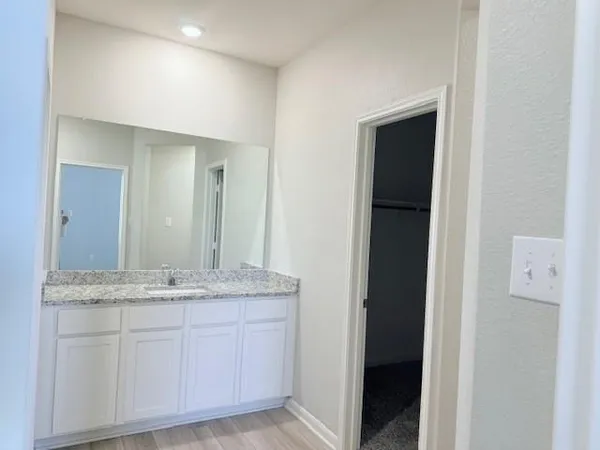 a bathroom with a granite countertop sink and a mirror