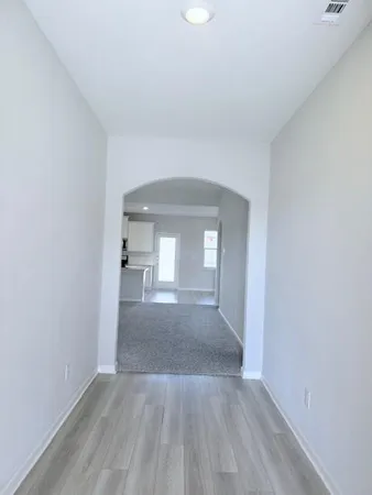 a view of a room that has wooden floor and white walls