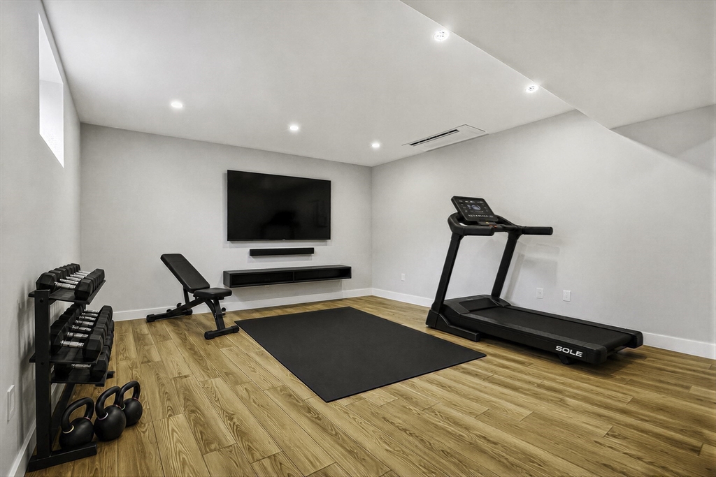 18 Avon Circle Needham, MA 02494 - Photo 17 of 18 a room with gym equipment and a flat screen tv