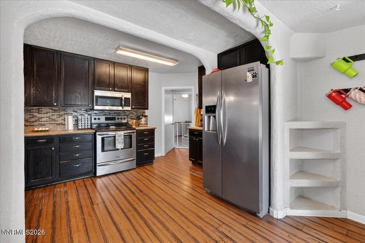 270 Vine Street Fernley, NV 89408 - Photo 21 of 28 a kitchen with stainless steel appliances granite countertop a refrigerator a stove and a wooden floors