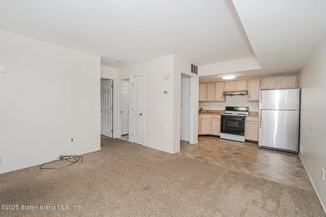 a view of a kitchen with white cabinets and stainless steel appliances