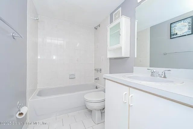a bathroom with a granite countertop sink a toilet and a bathtub