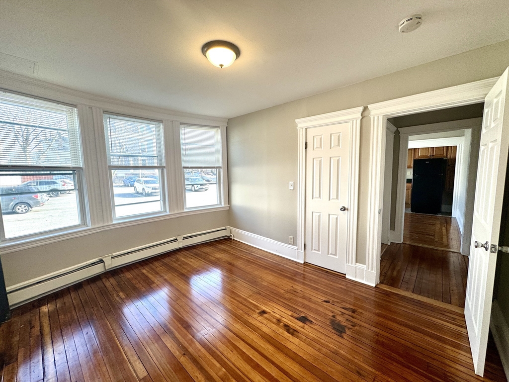 124 Green Street, Unit 206 Lynn, MA 01902 - Photo 3 of 7 wooden floor in an empty room with a window