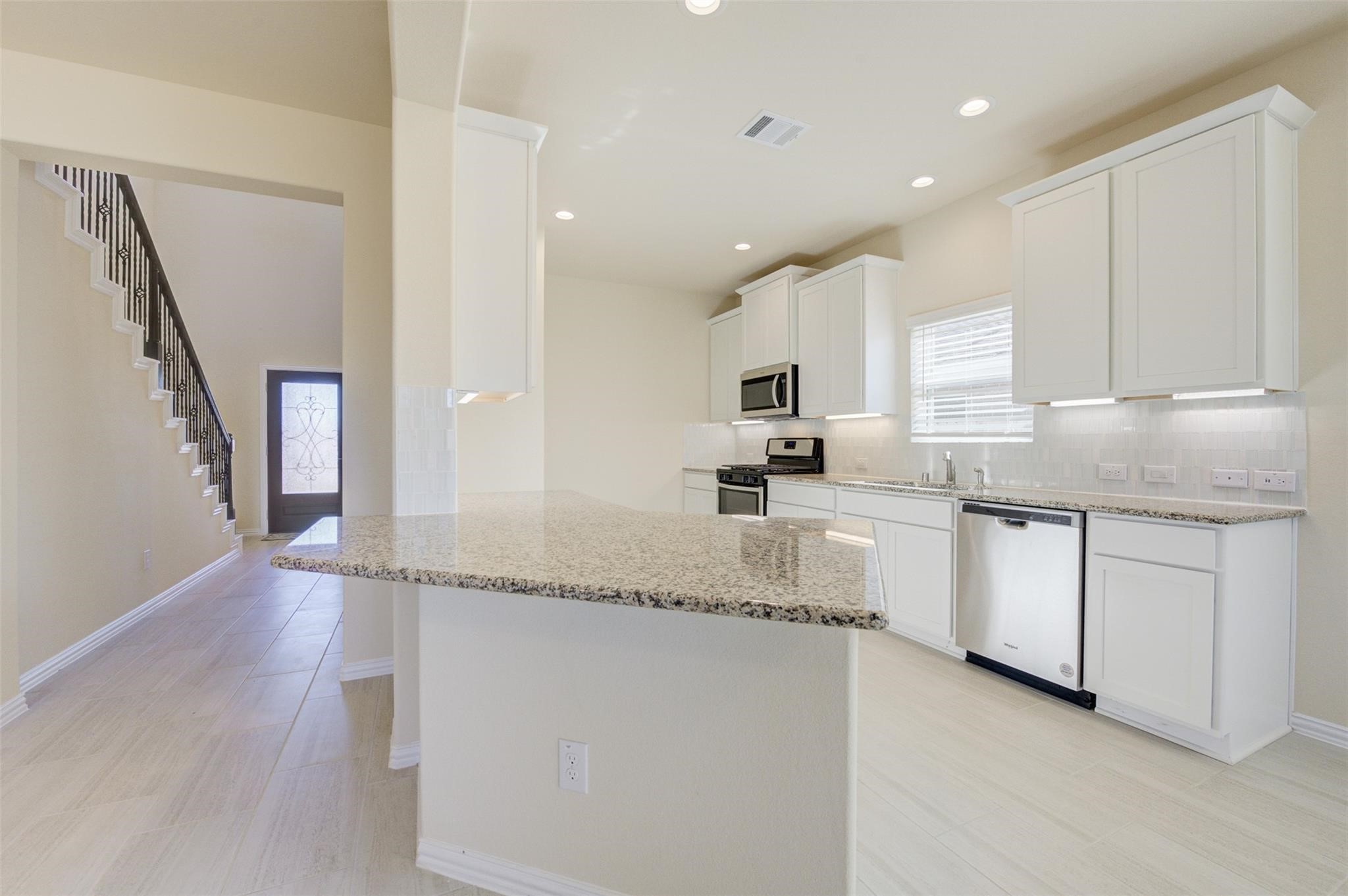 10902 Granite Chief Drive Rosharon, TX 77583 - Photo 11 of 32 a kitchen with granite countertop white cabinets and white appliances