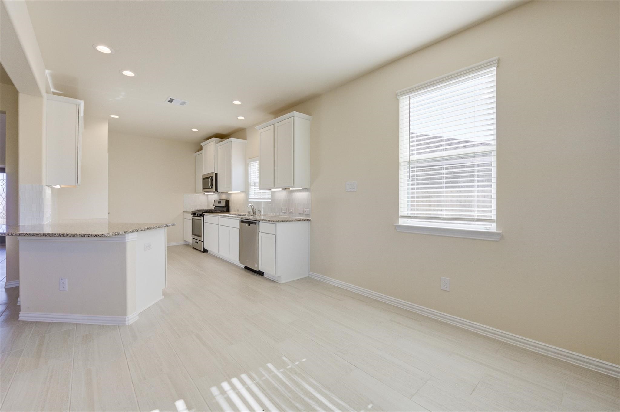 10902 Granite Chief Drive Rosharon, TX 77583 - Photo 12 of 32 a open kitchen with white cabinets and white appliances