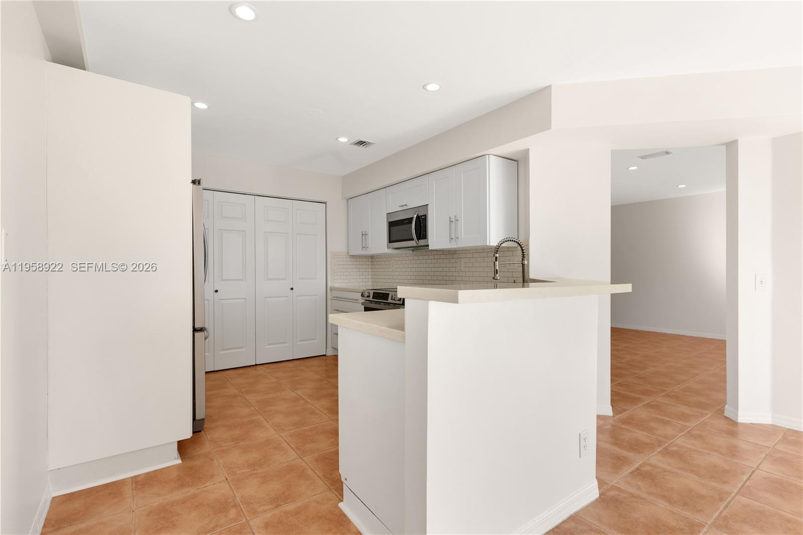 5467 Southwest 125th Terrace Miramar, FL 33027 - Photo 11 of 42 a view of a kitchen with refrigerator and a fireplace