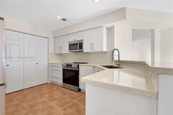 a kitchen with a sink stove and refrigerator