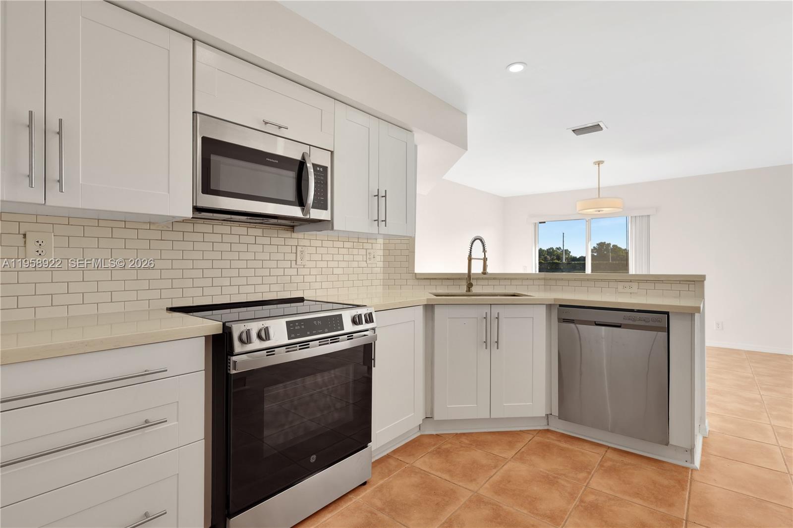 5467 Southwest 125th Terrace Miramar, FL 33027 - Photo 13 of 42 a kitchen with granite countertop cabinets stainless steel appliances and wooden floor