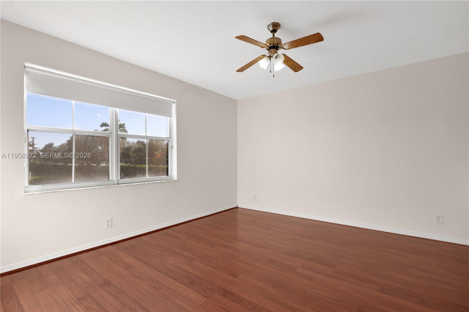 5467 Southwest 125th Terrace Miramar, FL 33027 - Photo 17 of 42 a view of a room with wooden floor and a ceiling fan