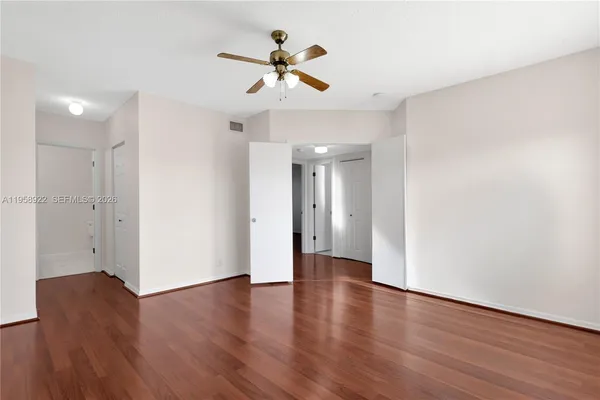 a view of a livingroom with wooden floor and a ceiling fan