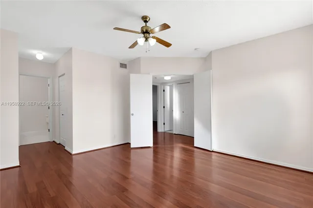 a view of a livingroom with wooden floor and a ceiling fan