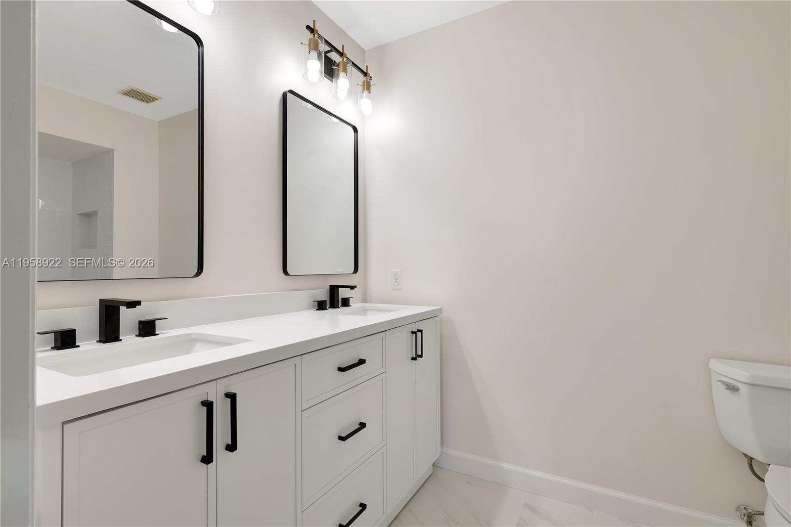 5467 Southwest 125th Terrace Miramar, FL 33027 - Photo 20 of 42 a bathroom with a double vanity sink and mirror