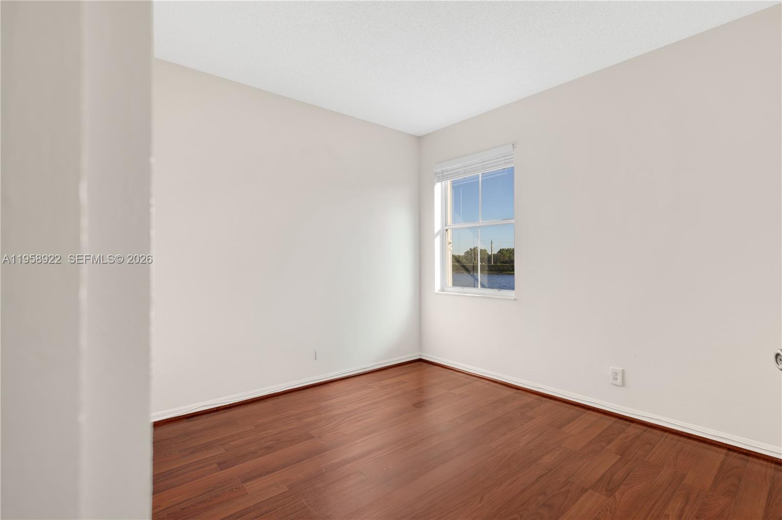 5467 Southwest 125th Terrace Miramar, FL 33027 - Photo 23 of 42 a view of an empty room with wooden floor and a window