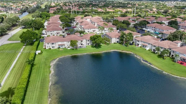 an aerial view of a houses with a yard and lake view