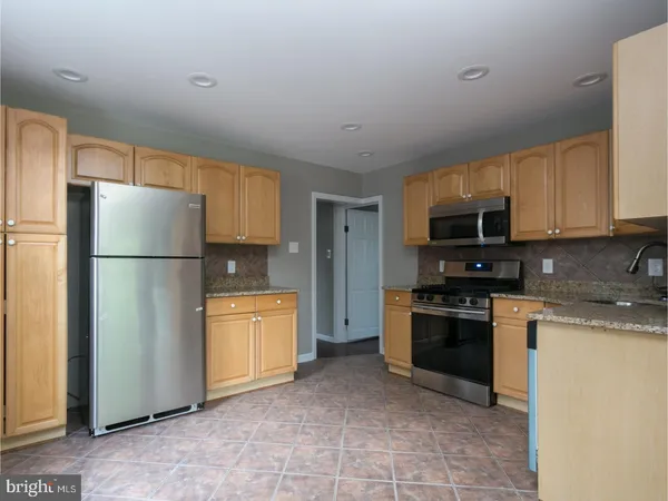 a kitchen with stainless steel appliances granite countertop a refrigerator stove a sink dishwasher and microwave