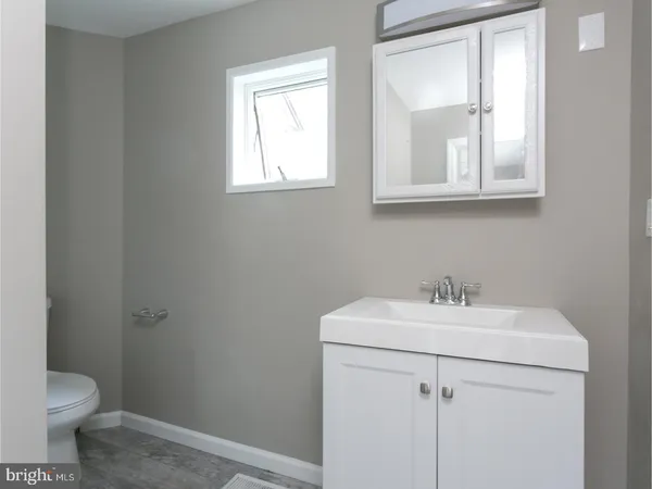 a bathroom with a sink toilet and mirror