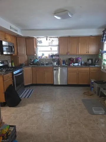 a kitchen with stainless steel appliances kitchen island granite countertop a sink stove and granite counter top