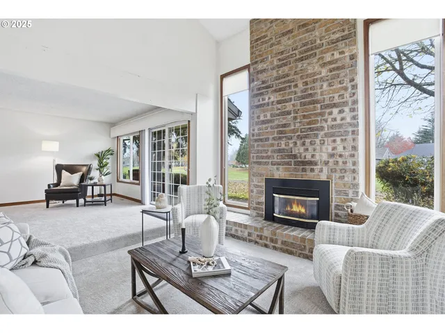 a living room with furniture a fireplace and a floor to ceiling window