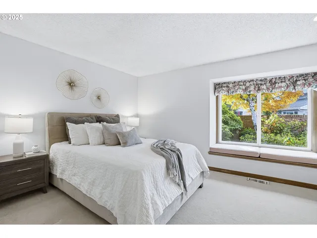 a bedroom with a bed and a large window