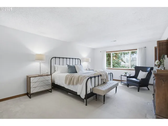 a spacious bedroom with a bed a couch and a window