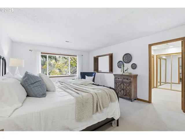 a bedroom with a large bed and a window