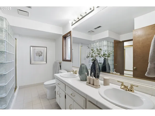 a bathroom with a double vanity sink mirror and toilet