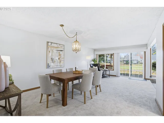 a view of a dining room and livingroom with furniture wooden floor a rug and a chandelier