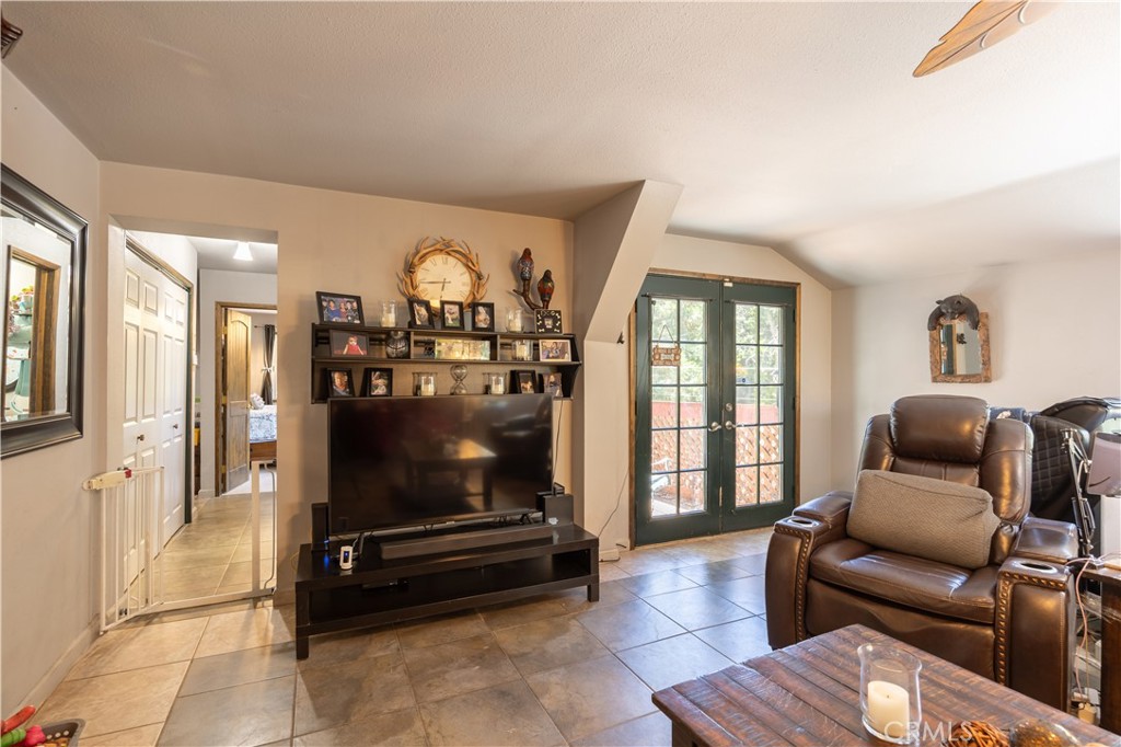 519 South Dart Canyon Road Crestline, CA 92325 - Photo 13 of 26 a living room with furniture a flat screen tv and a floor to ceiling window