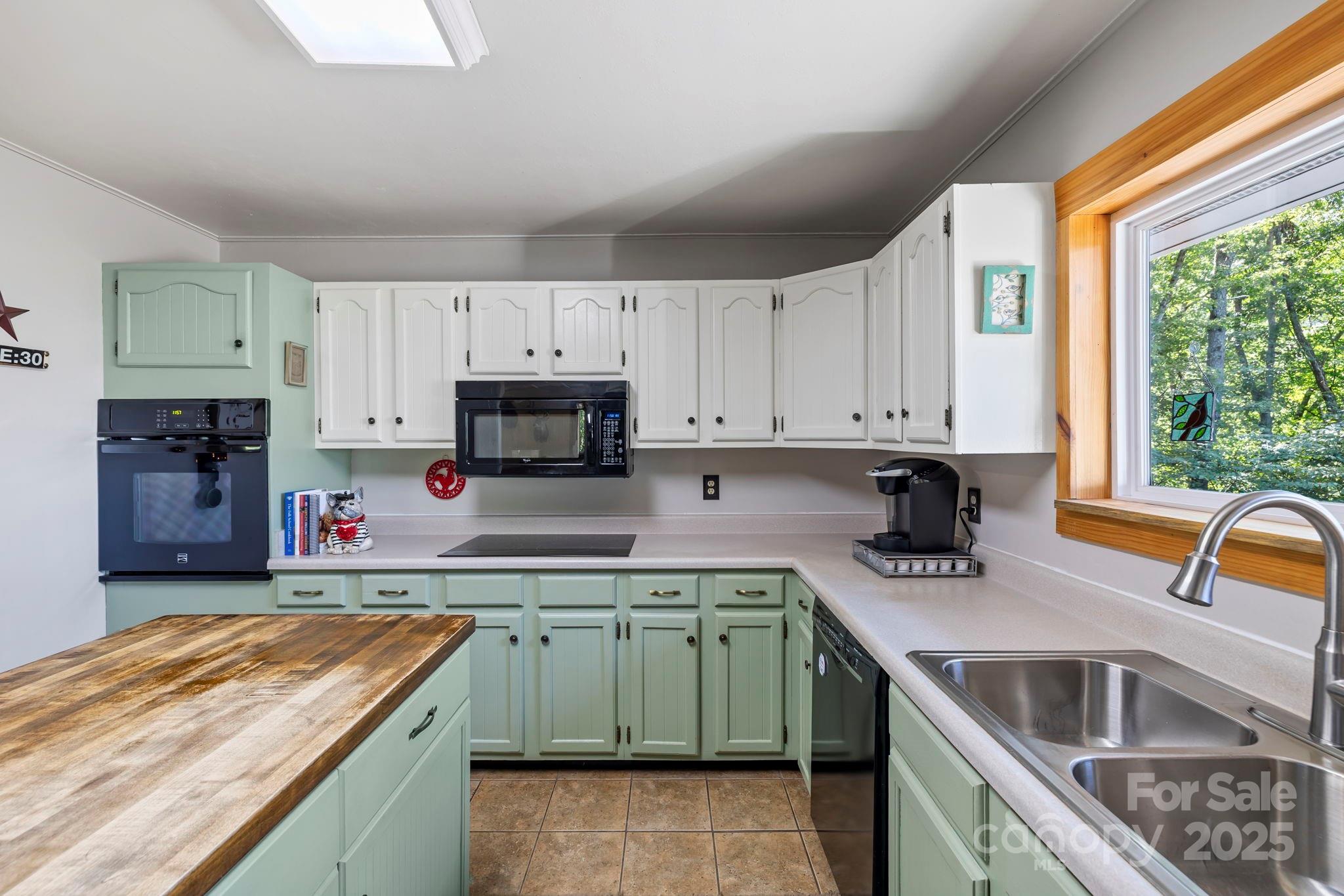 658 Johnson Road Brevard, NC 28712 - Photo 22 of 48 a kitchen with kitchen island granite countertop a sink a counter top space appliances and cabinets