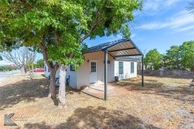 a view of a backyard with large trees