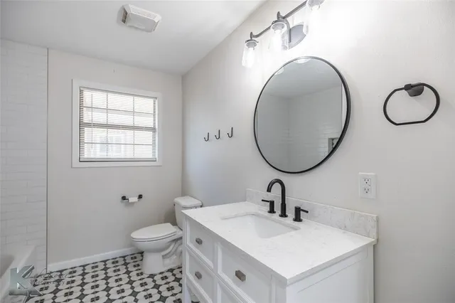 a bathroom with a sink a toilet and a mirror