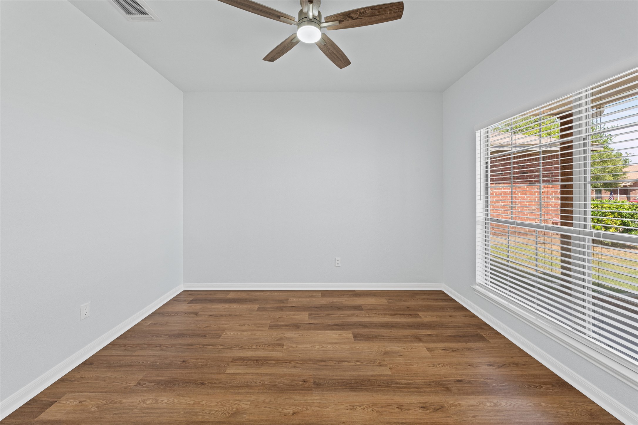 243 Engineers Pass Jarrell, TX 76537 - Photo 6 of 40 Interior room featuring wood-finish flooring, white baseboards, and a ceiling fan with integrated lighting