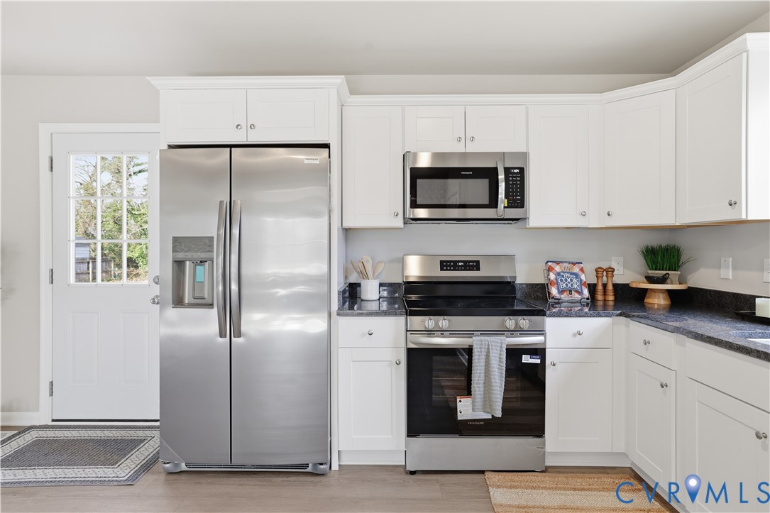 4400 Treely Road Chester, VA 23831 - Photo 12 of 34 a kitchen with stainless steel appliances granite countertop a refrigerator a stove a sink and white cabinets with wooden floor